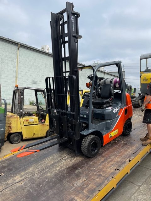 Used Forklift being loaded onto a tow truck for delivery to a happy customer